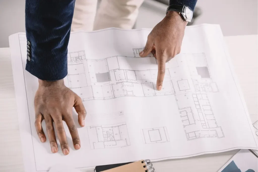 Arquitecto señalando detalles en planos durante revisión técnica en Montevideo